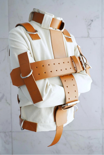 Straightjacket, Restraint jacket, Heavy duty apparel, Technical garment, Structured jacket, Heavy canvas, Cotton duck fabric, Premium leather straps, Genuine cowhide, Metal D-rings, Reinforced stitching, Bespoke tailoring, High-end alternative fashion, Avant-garde apparel, Heavy-duty gear, Cosplay costume, Studio photography prop
