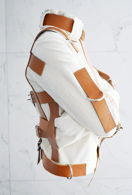 Straightjacket, Restraint jacket, Heavy duty apparel, Technical garment, Structured jacket, Heavy canvas, Cotton duck fabric, Premium leather straps, Genuine cowhide, Metal D-rings, Reinforced stitching, Bespoke tailoring, High-end alternative fashion, Avant-garde apparel, Heavy-duty gear, Cosplay costume, Studio photography prop